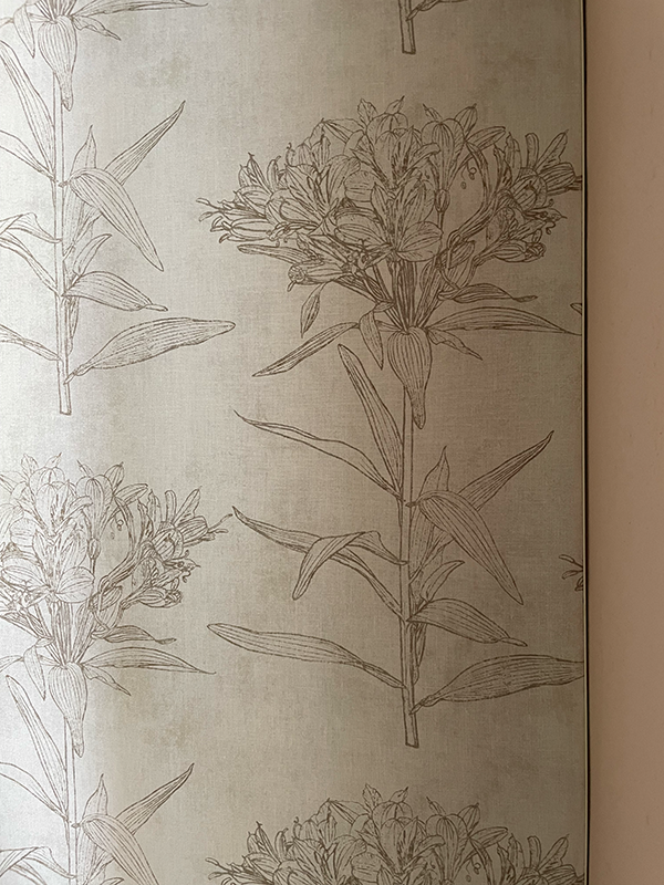 Close-up of wallpaper with a repeating pattern of stylized flowers and leaves in soft brown on beige background.